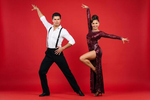 male-and-female-latin-dancers-performing-elegant-moves-on-a-red-background-photo